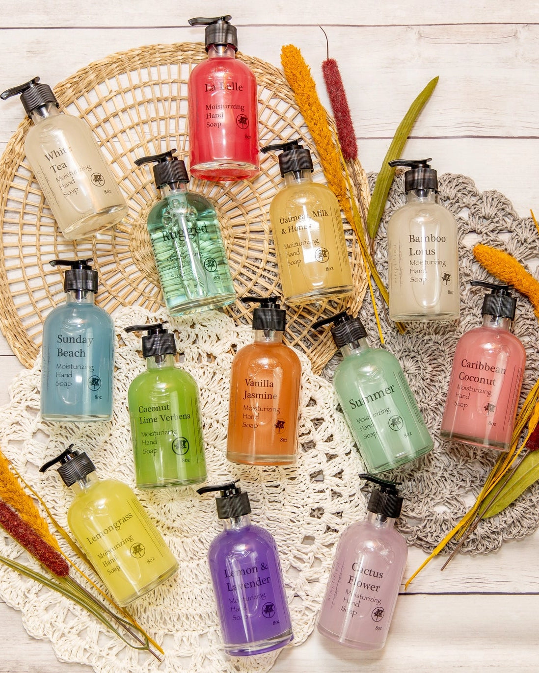 Colorful mix of hand soaps in glass bottles on wood background.