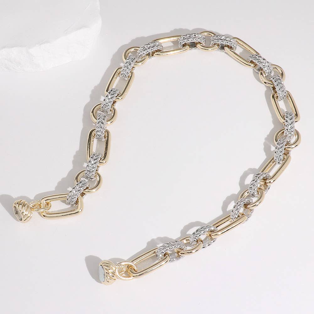 Gold and silver chain necklace on a white background.
