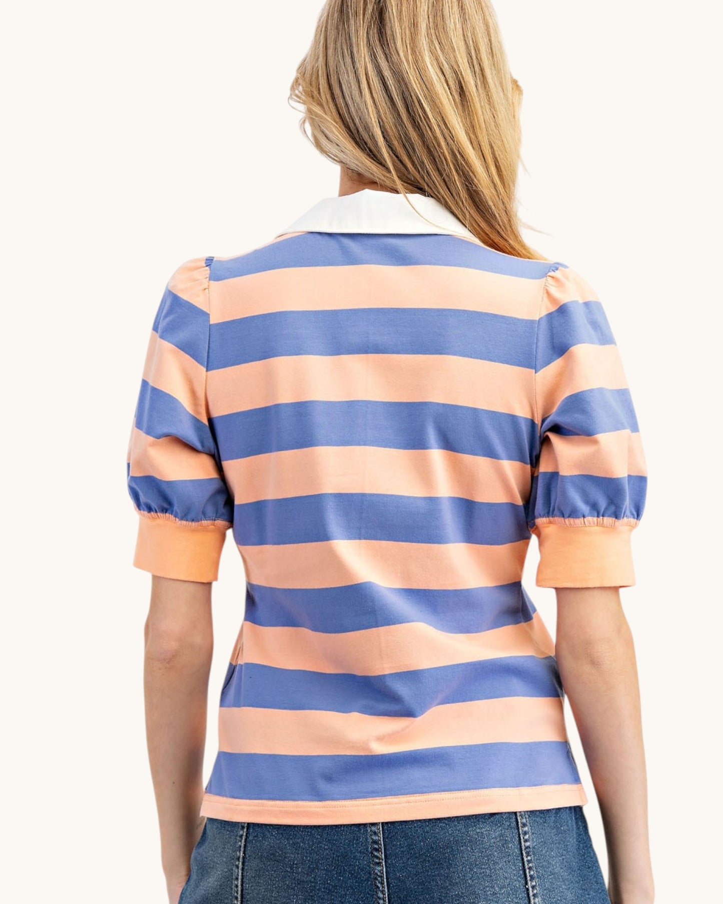 Woman wearing a blue and orange striped polo shirt on a white background.