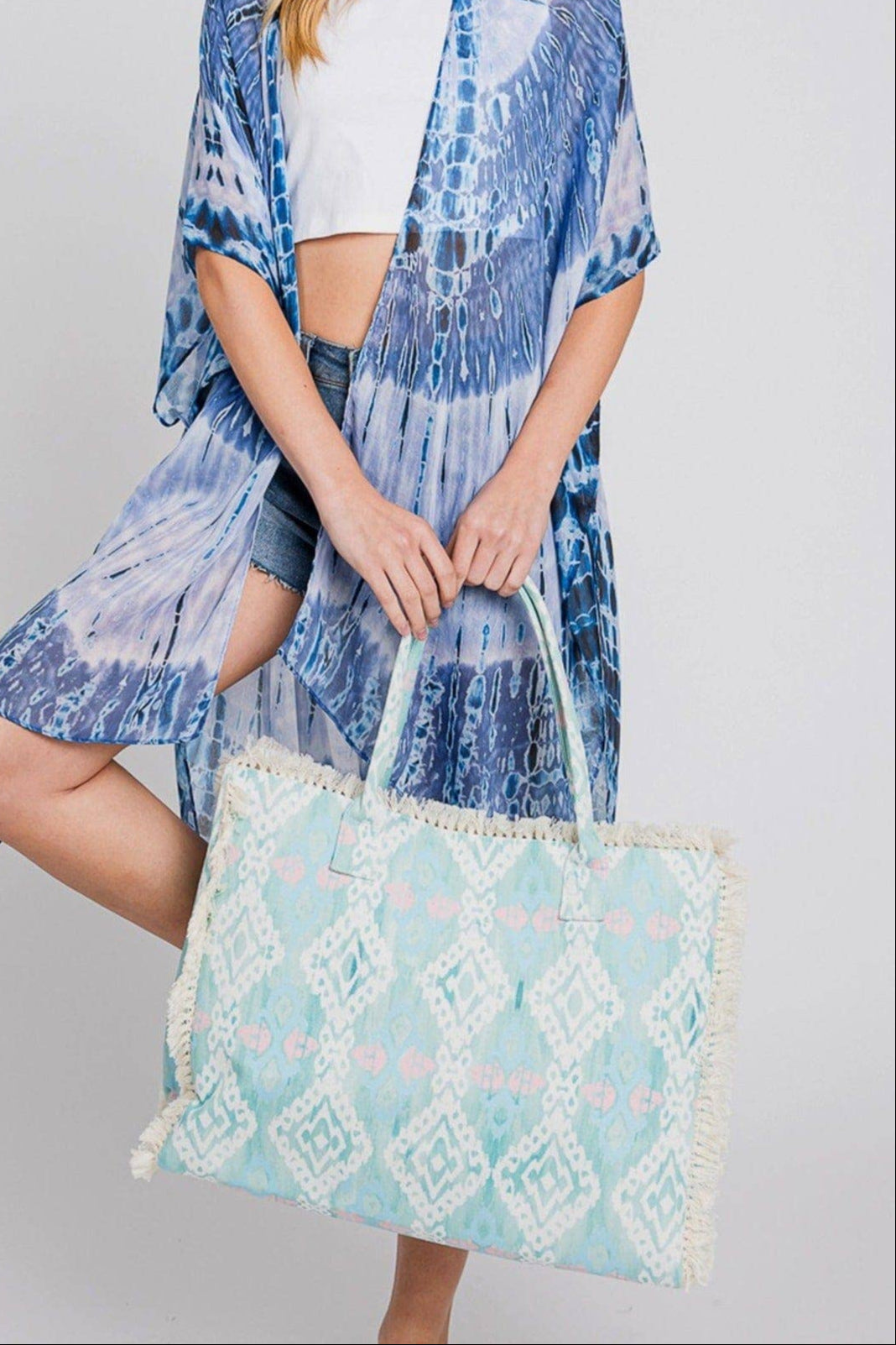 Aqua blue fringe boho beach bag with snap closure and soft texture.