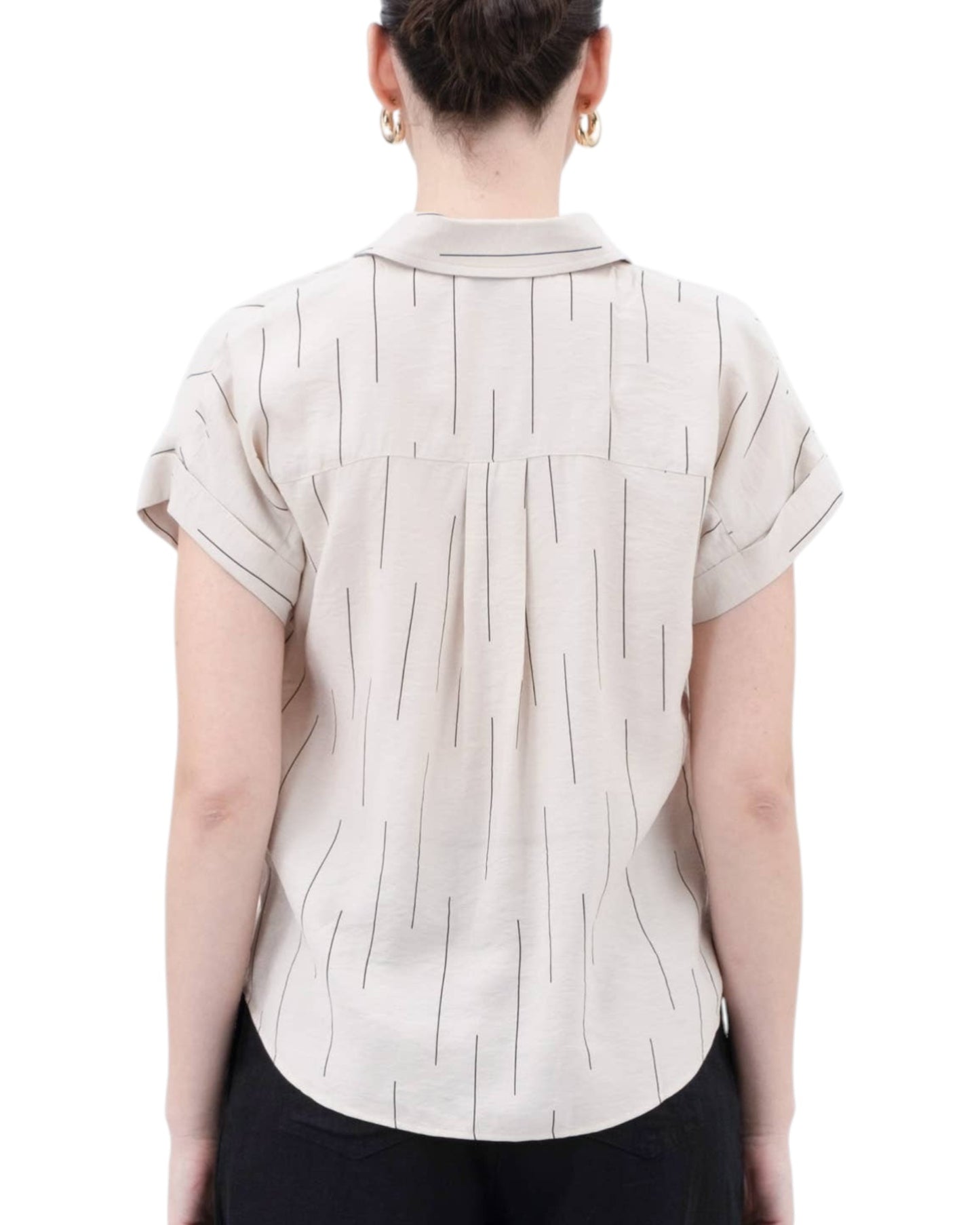 Person wearing a beige short-sleeve blouse with a subtle black line pattern on a white background.