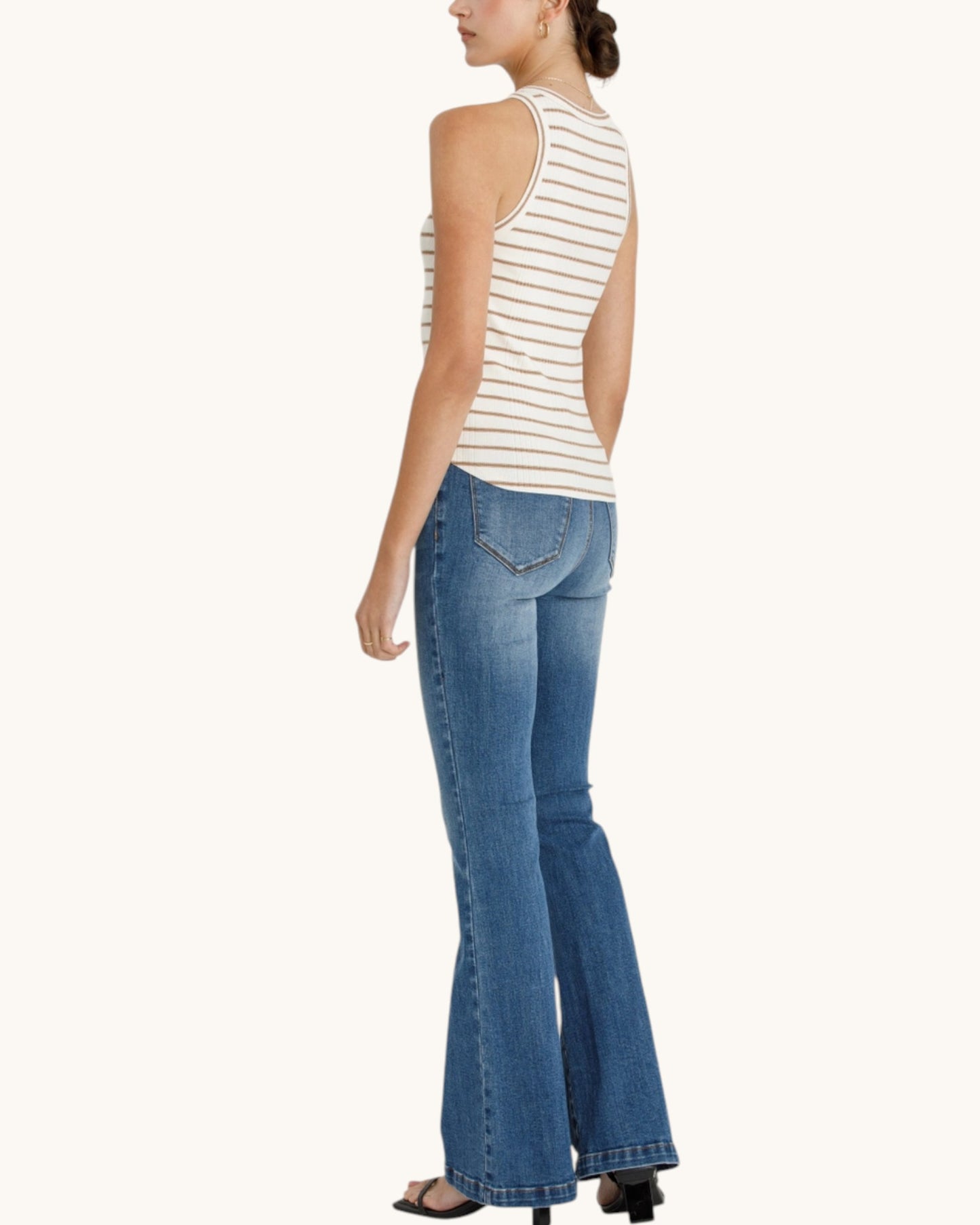Side/back view of the Cream & Biscotti Stripe Tank Top with denim and black sandals.