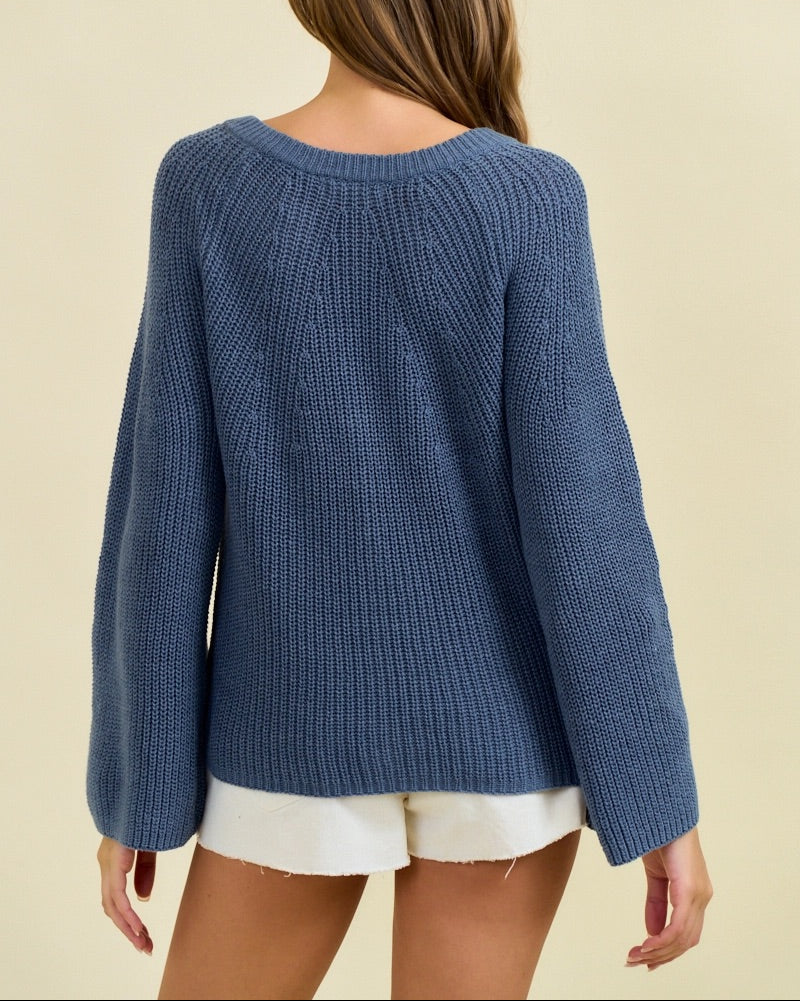 Woman wearing a blue knitted sweater on a beige background.