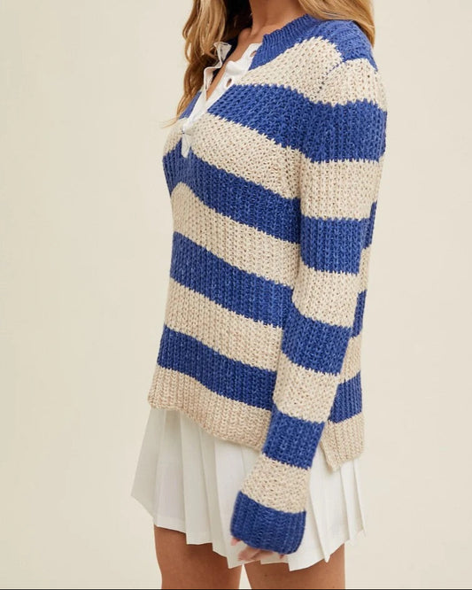 Woman wearing a blue and white striped sweater on a beige background.