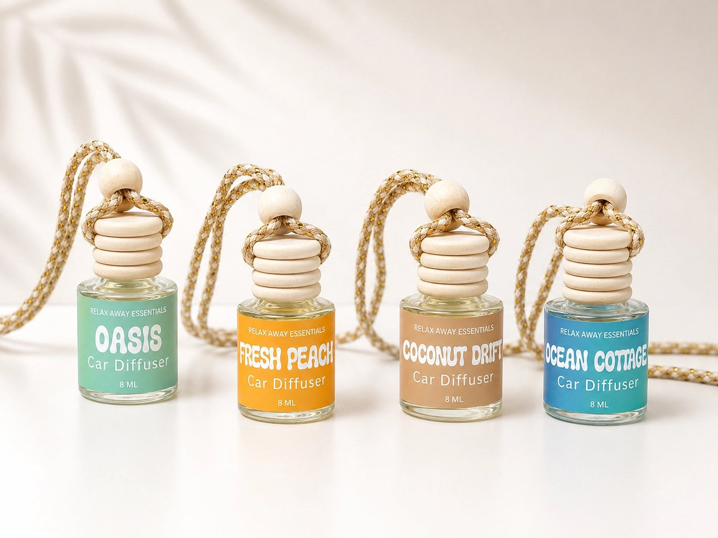 Four car diffuser bottles with different scents on a white background.
