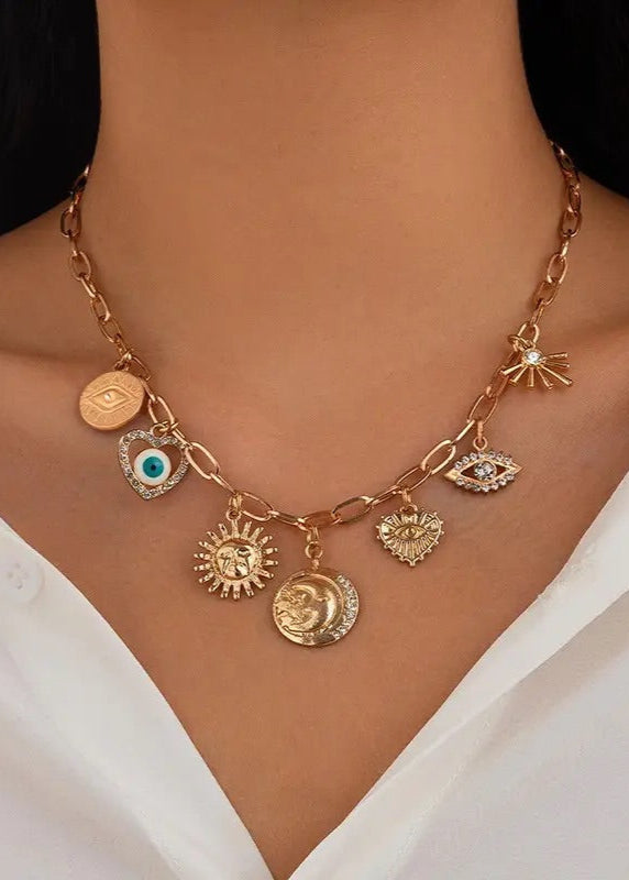 Chic, Gold-plated charm necklace with Sun, Evil Eye, Heart, and Hammered Disc charms, adjustable ball chain extension, and lobster clasp closure.
