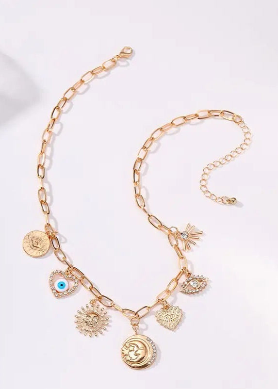Gold-plated charm necklace with Sun, Evil Eye, Heart, and Hammered Disc charms, adjustable ball chain extension, and lobster clasp closure.