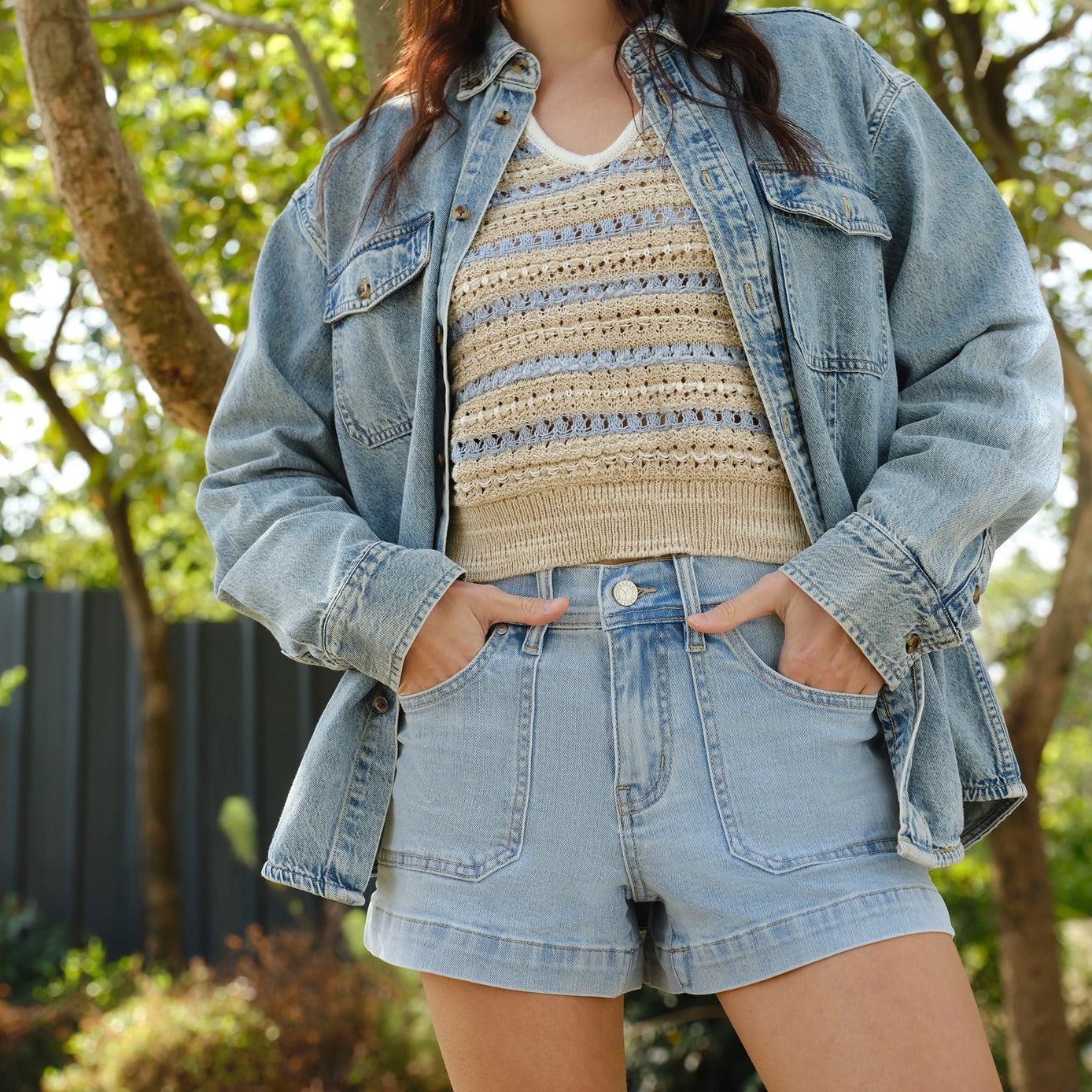 Light blue mid-rise denim shorts with finished hem, elastic waistband, and classic five-pocket style.