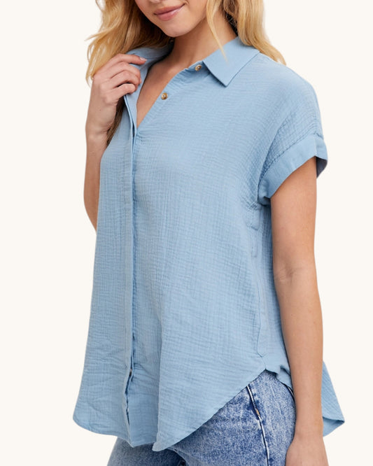 Woman wearing a light blue shirt with a white background.