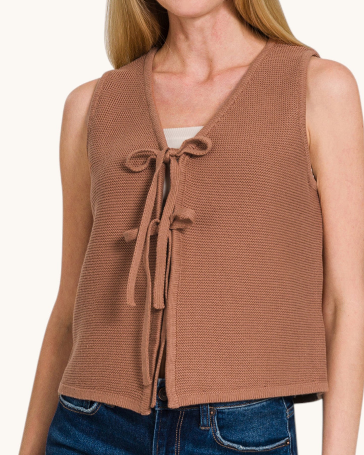 Brown knit vest with tie front worn by a person on a white background.