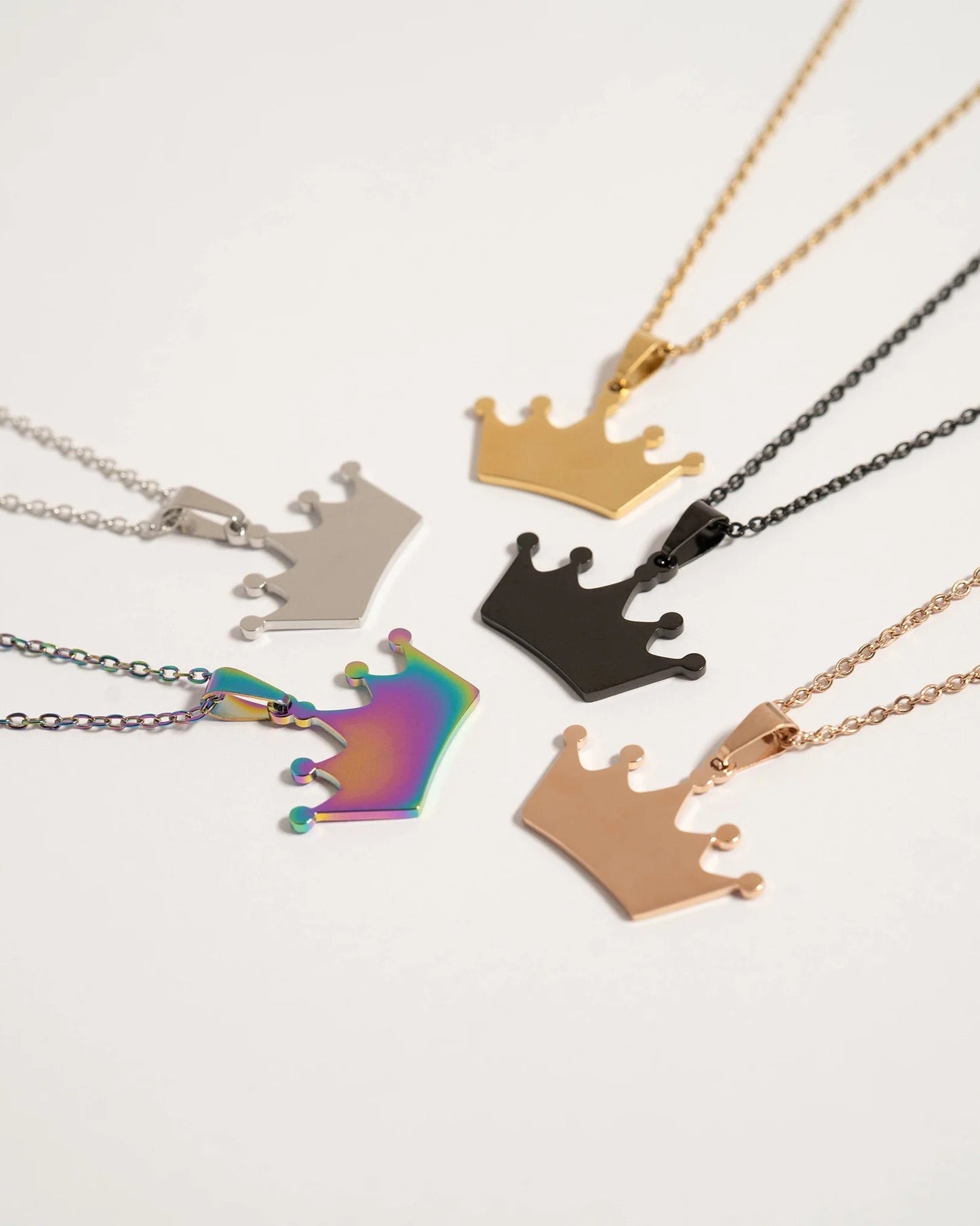 Collection of crown-shaped necklaces in various colors on a white background.