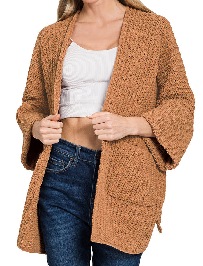 Woman wearing a Deep Camel Chunky Knit Boxy cardigan with dark jeans on a white background.