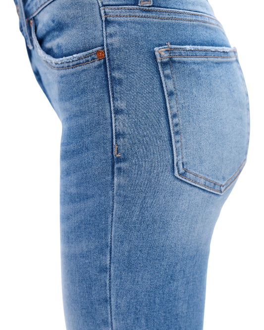 Close-up of blue jeans on a white background.