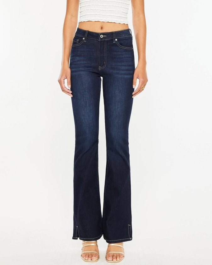 Woman wearing Kan Can Dark Wash High Rise Bootcut Jeans with side slit detail.