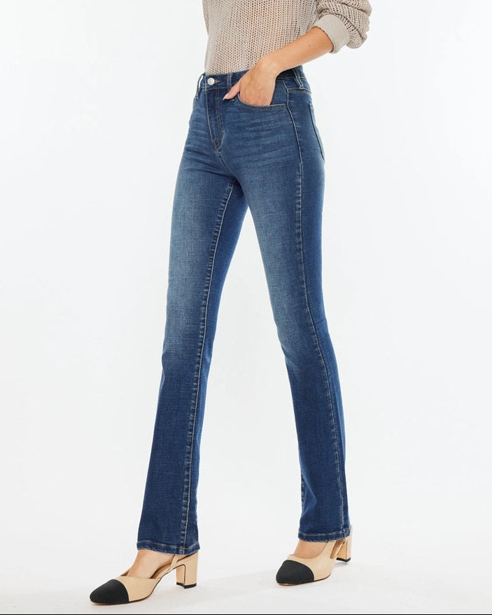 Woman wearing Kan Can High Rise Skinny Bootcut Jeans in medium wash denim.