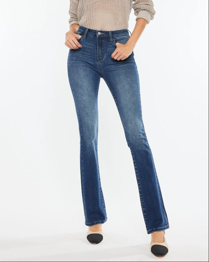 Woman wearing Kan Can High Rise Skinny Bootcut Jeans in medium wash denim.