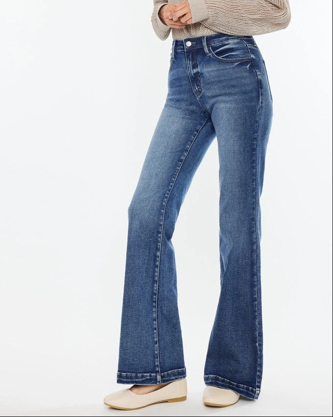 Woman wearing Kan Can High Rise Wide Leg Flare Jeans in medium wash denim.