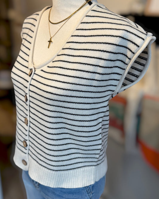 Striped sweater vest on a mannequin with a blurred background.