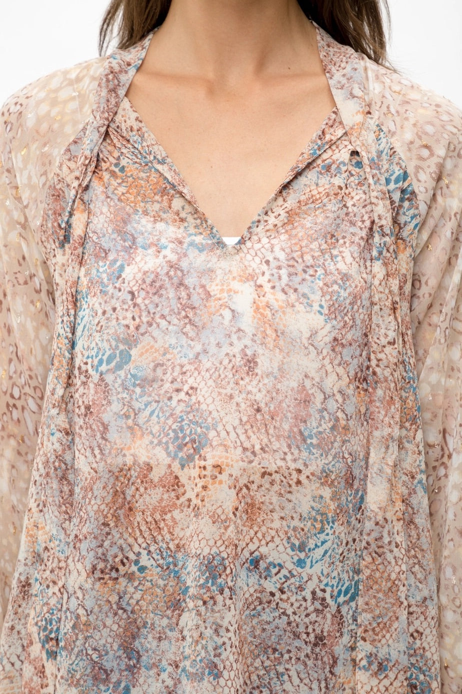 Mixed animal print patterned semi-sheer long sleeve blouse with a V-neckline and tie front.