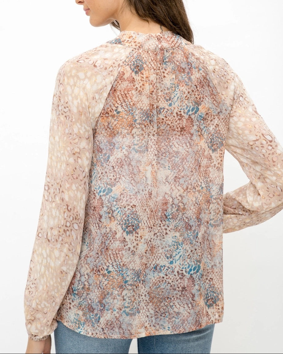 Mixed animal print patterned semi-sheer long sleeve blouse with a V-neckline and tie front.