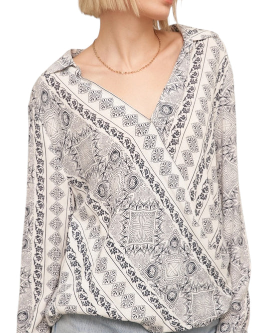 Woman wearing a patterned blouse with a white background.