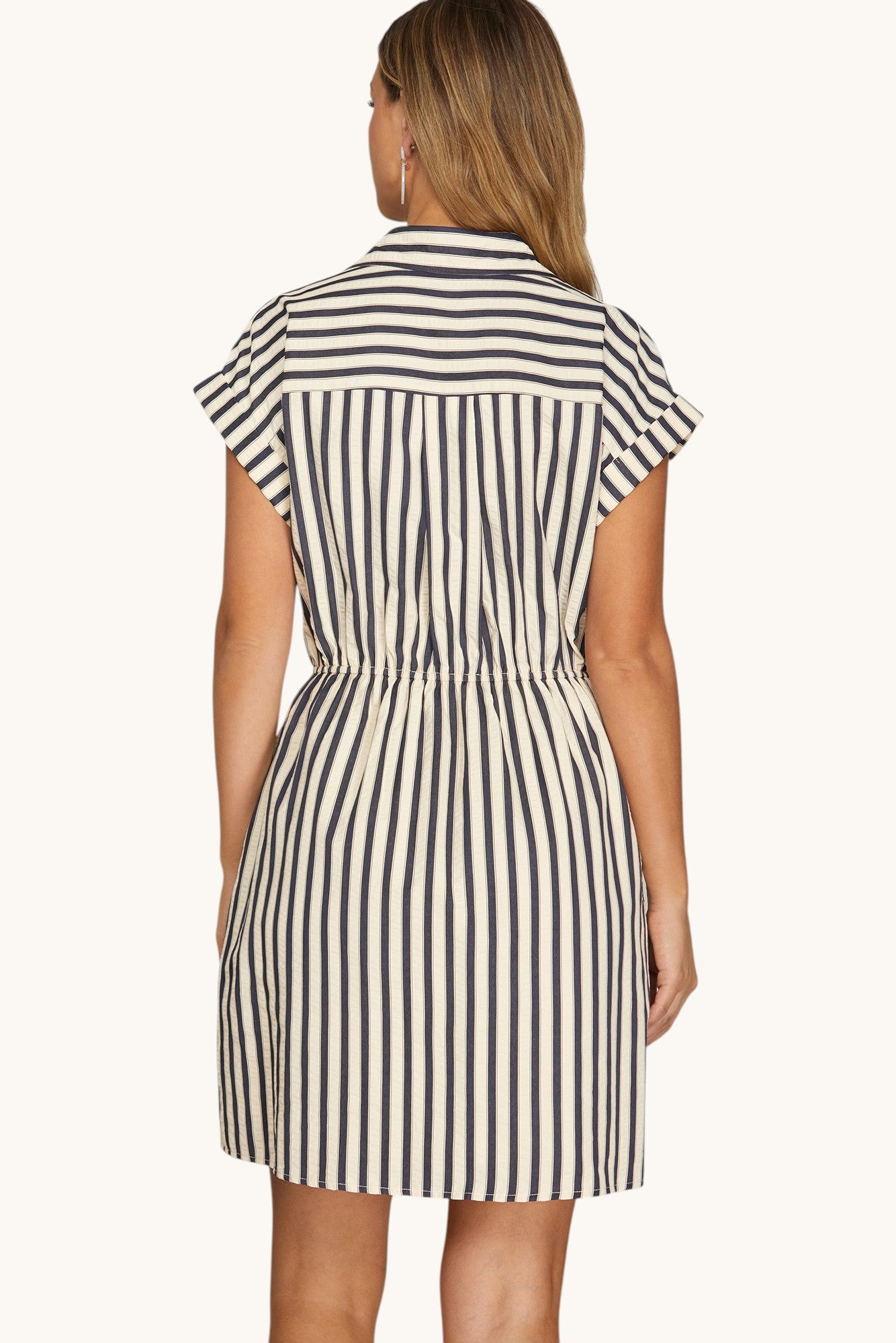 Back view of a woman wearing a Navy and Ivory Stripe short sleeve mini dress.