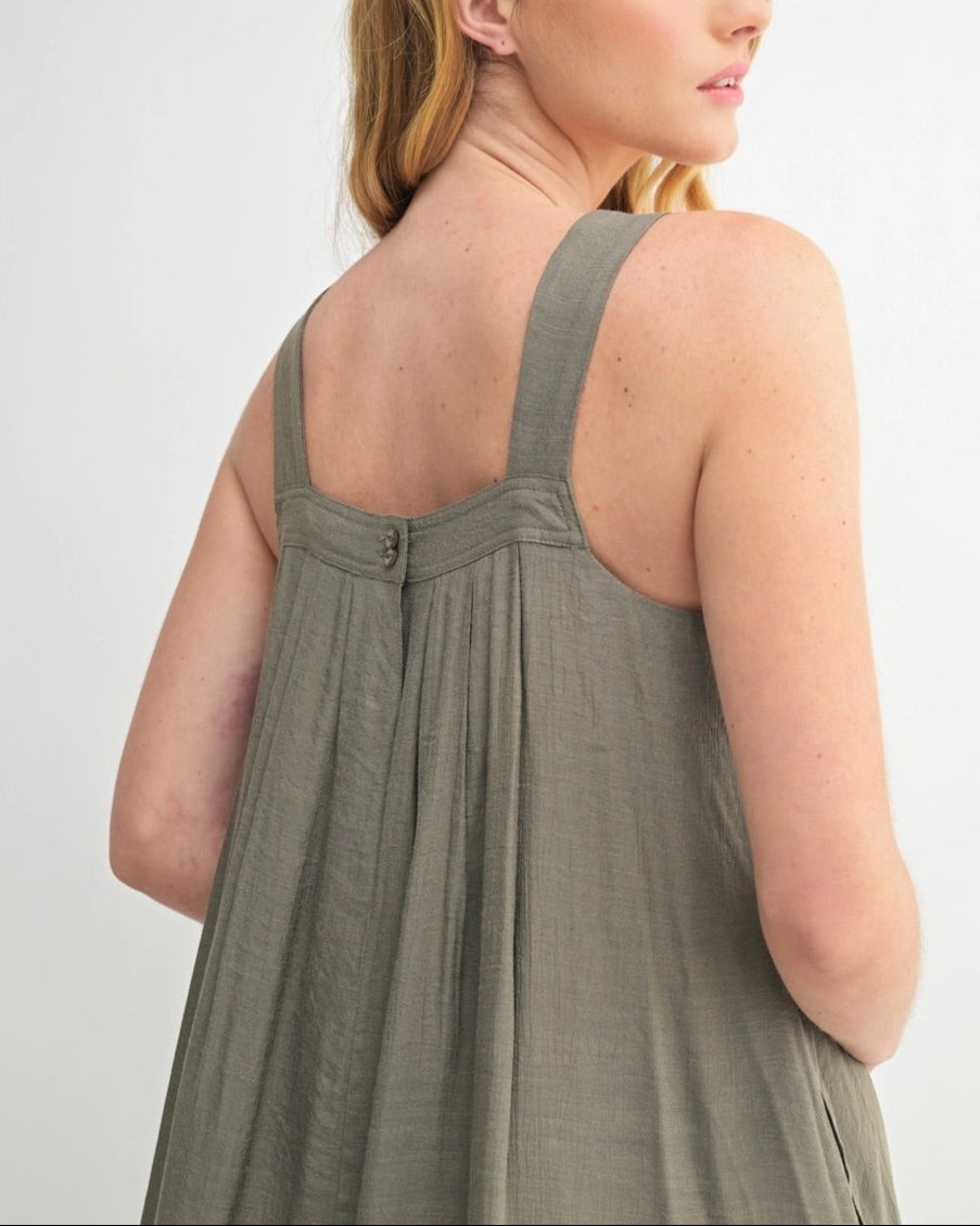 Woman wearing an Olive Green square neck midi dress with wide straps and pleats.