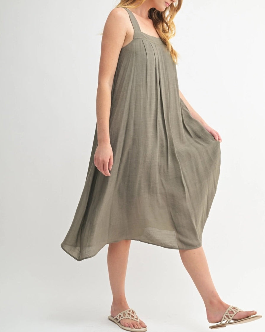 Woman wearing an Olive Green square neck midi dress with wide straps and pleats.