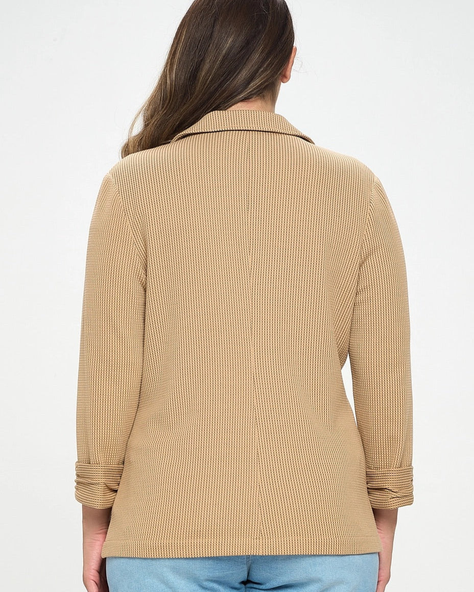 Woman wearing a beige ribbed sweater and light blue shorts on a white background.