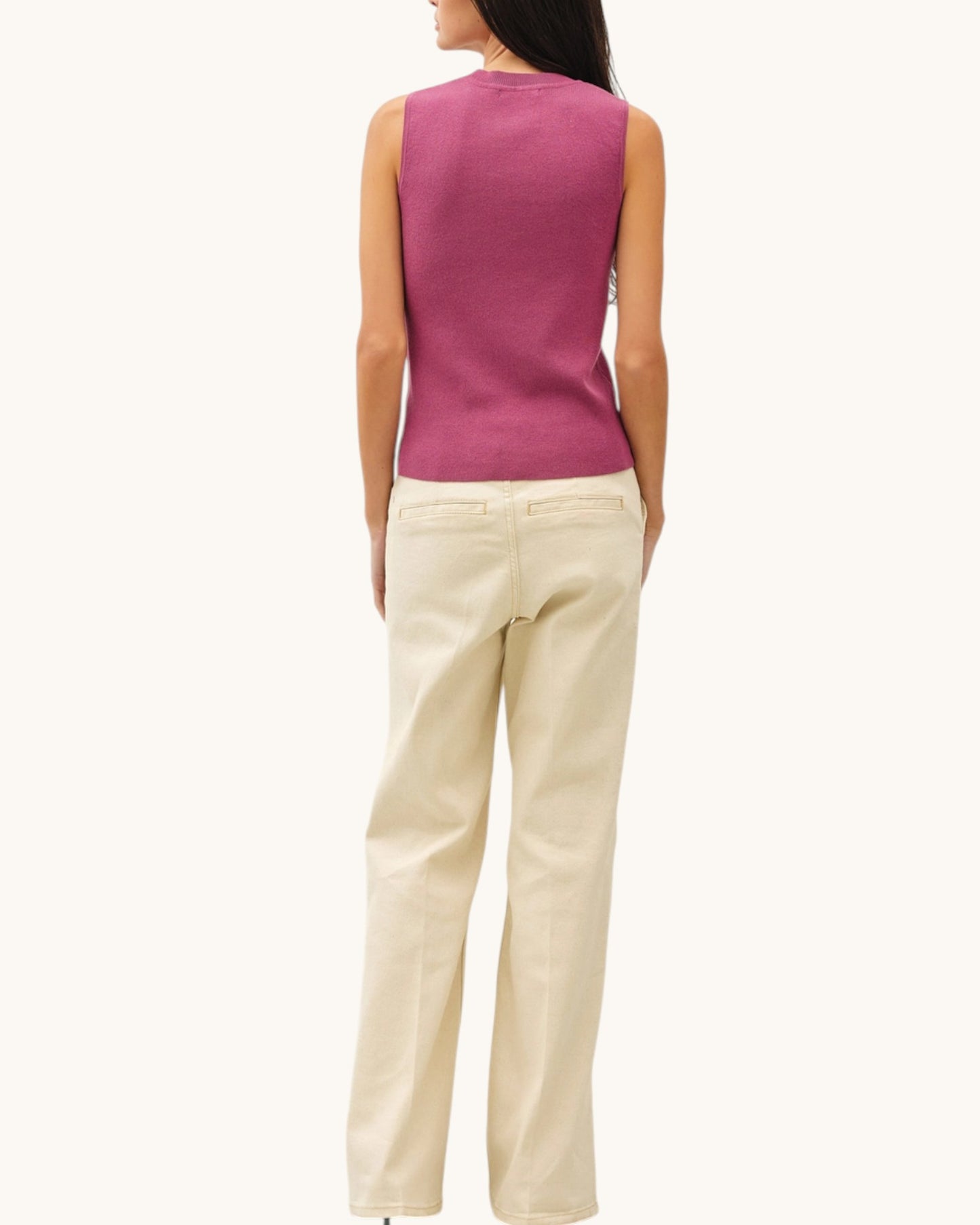 Back view of a woman wearing a Mauve sleeveless top and beige pants on a white background.
