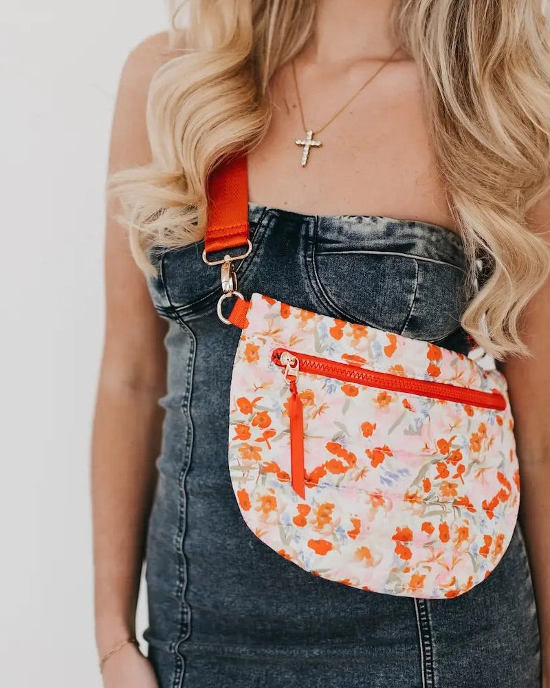 White and orange floral quilted puffer belt bag with gold hardware and adjustable strap.