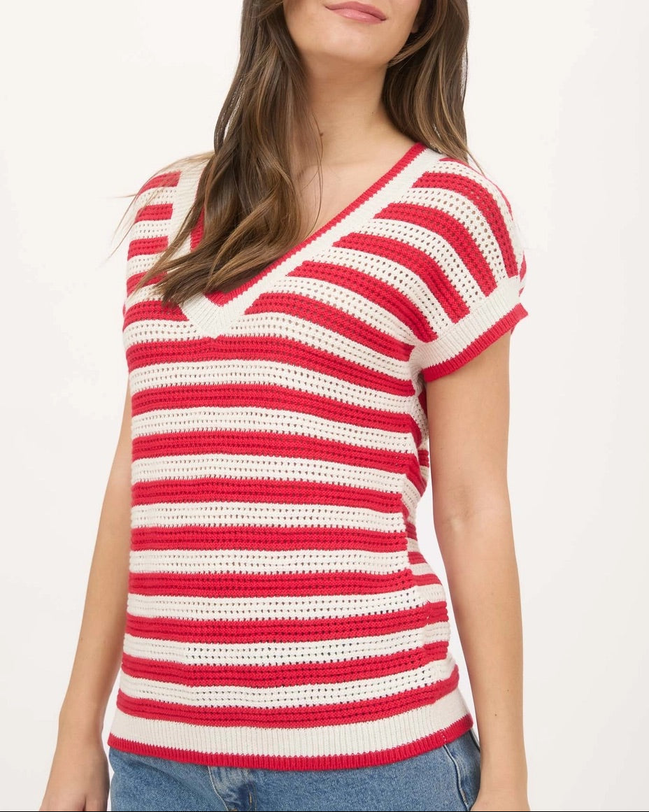 Woman wearing a red and cream V neck crochet short sleeve sweater with relaxed fit.