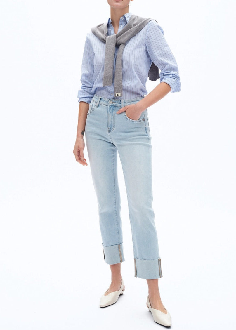 High-rise light blue jeans with rolled hem, five-pocket design, and whisker wash details.