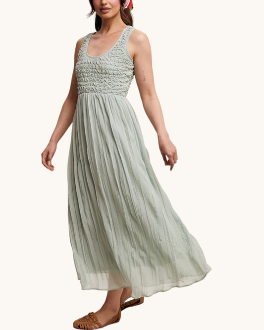 Woman wearing a light green sleeveless dress on a white background.