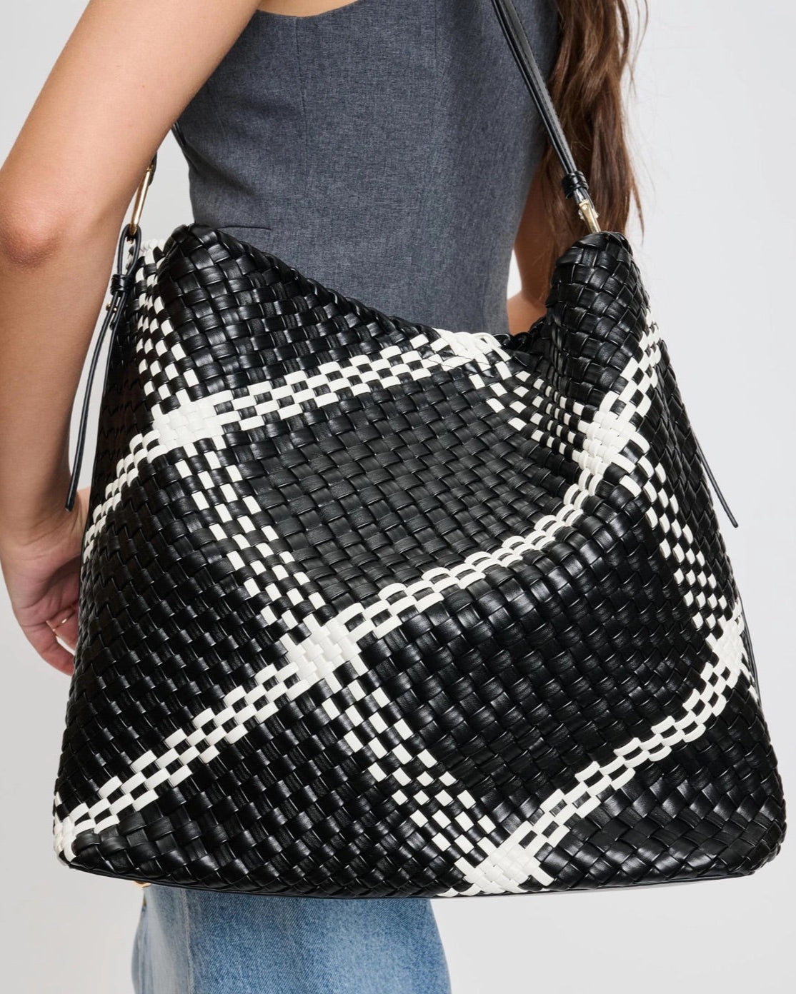Black and white woven plaid hobo bag with adjustable shoulder strap.