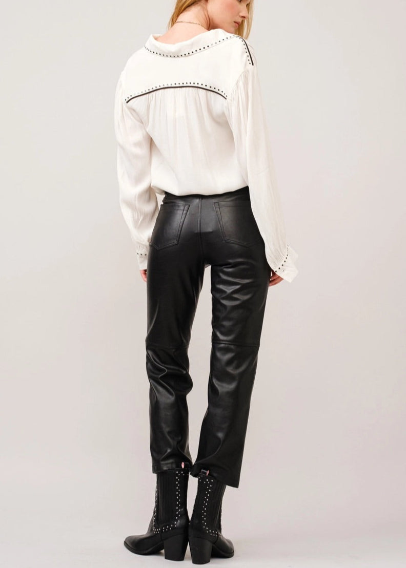 White crepe blouse with studded details, black piping on shoulders, classic collar, and slit neckline with hook closures.
