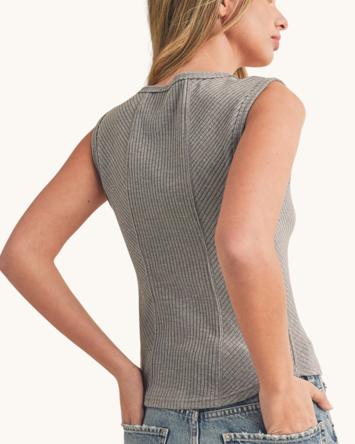 Back view of a woman wearing a grey ribbed sleeveless tank top with sweetheart neckline.