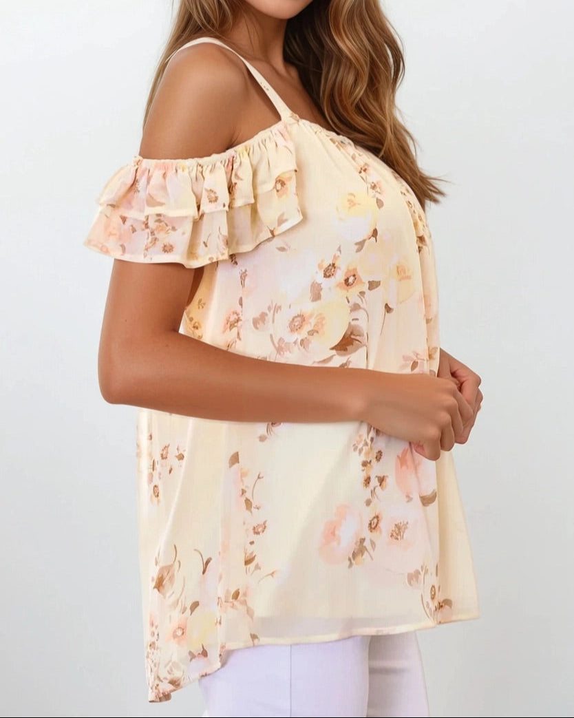 Woman wearing a Buttercream yellow off shoulder floral top with ruffle neckline and wide straps.
