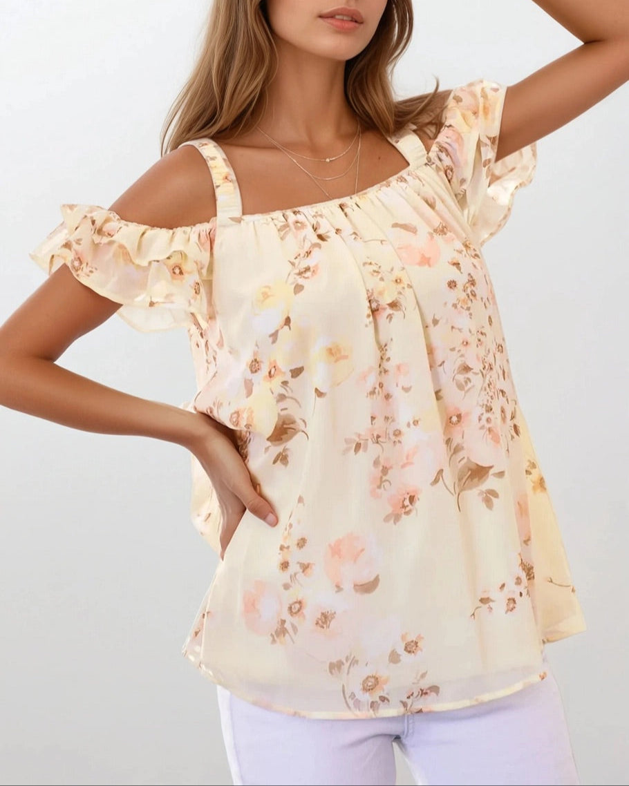 Woman wearing a floral off-shoulder blouse against a plain background.