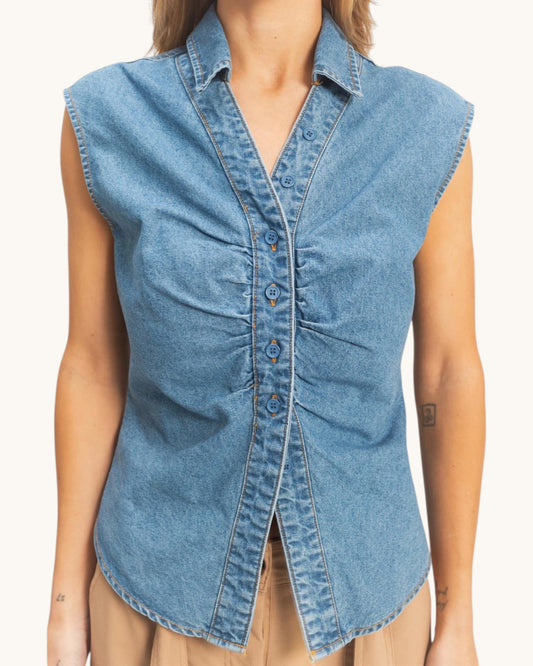 Denim sleeveless shirt worn by a person on a white background