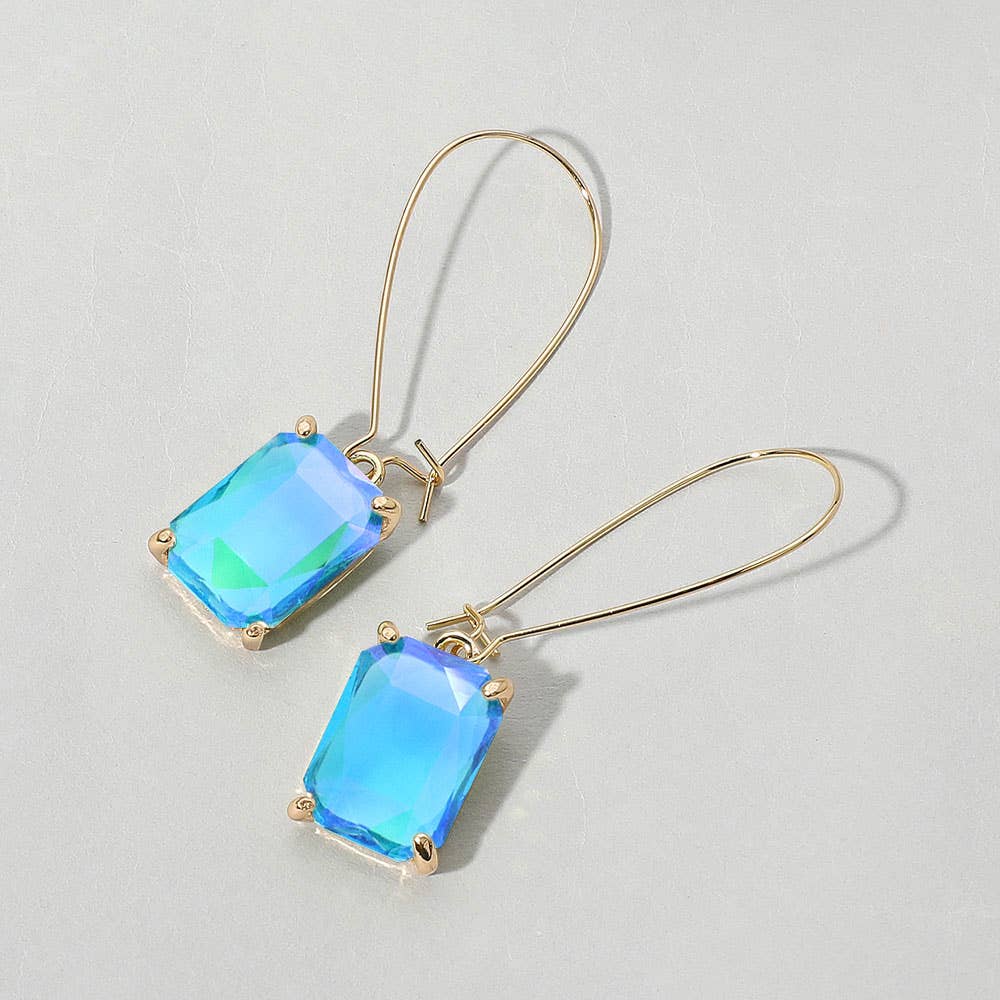 Gold earrings with blue-green crystal gemstones on a light gray background.