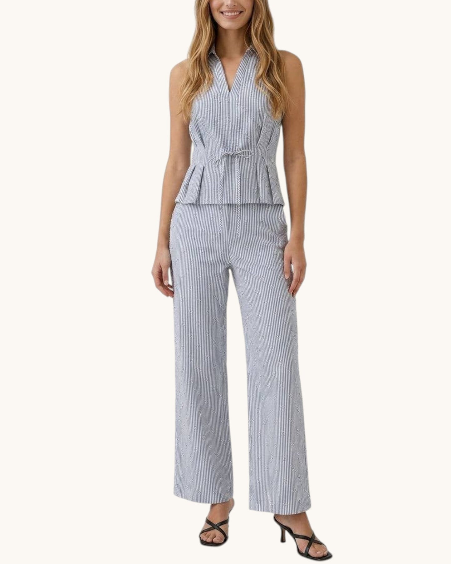 Woman wearing a black and white striped linen pant on a white background.
