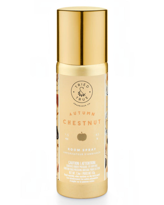 A bottle of Tried True Apothecary 'Autumn Chestnut' room spray with a metallic gold cap and a beige label featuring a chestnut illustration, set against a plain white background.