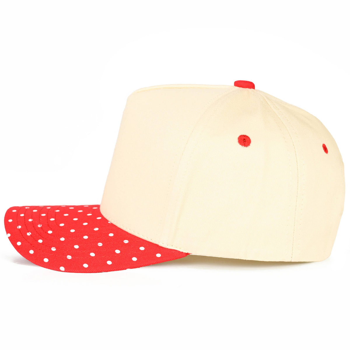 Beige baseball cap with red visor and white polka dots on a white background