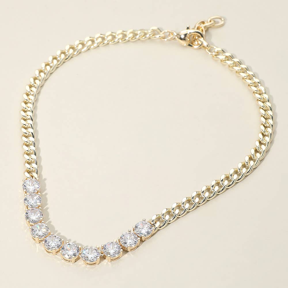 Gold statement necklace with CZ stones on a beige background.