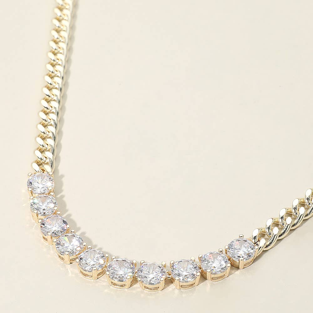 Gold necklace with large statement CZ gemstones on a beige background.
