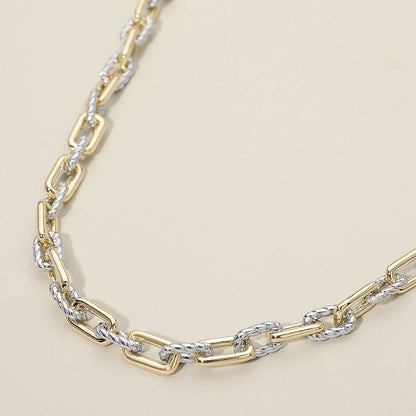 Two-tone gold and silver chain necklace on a beige background.