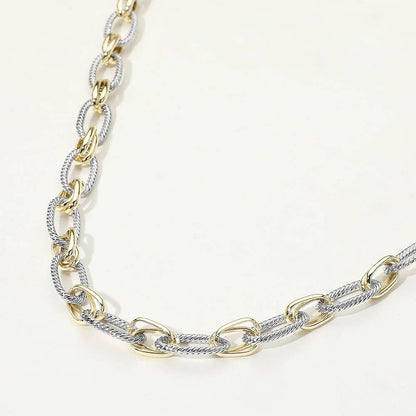 Gold and silver chain necklace on a light background.