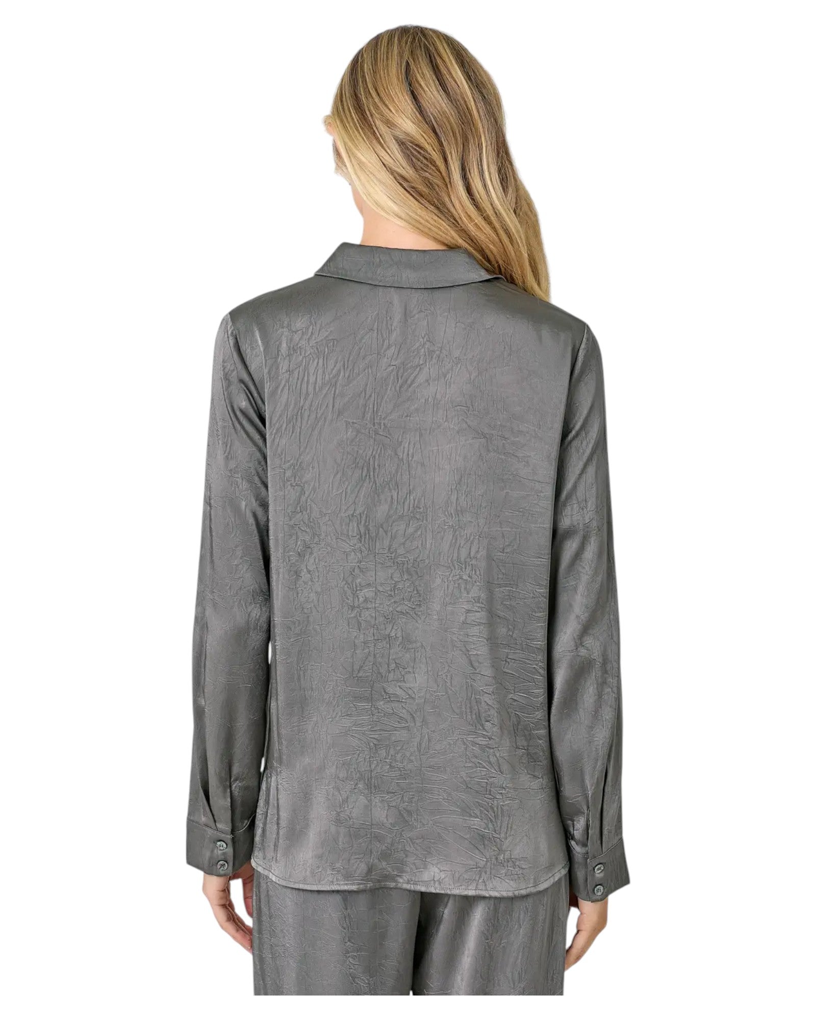 Woman wearing a grey button up crinkle satin twist front blouse. 