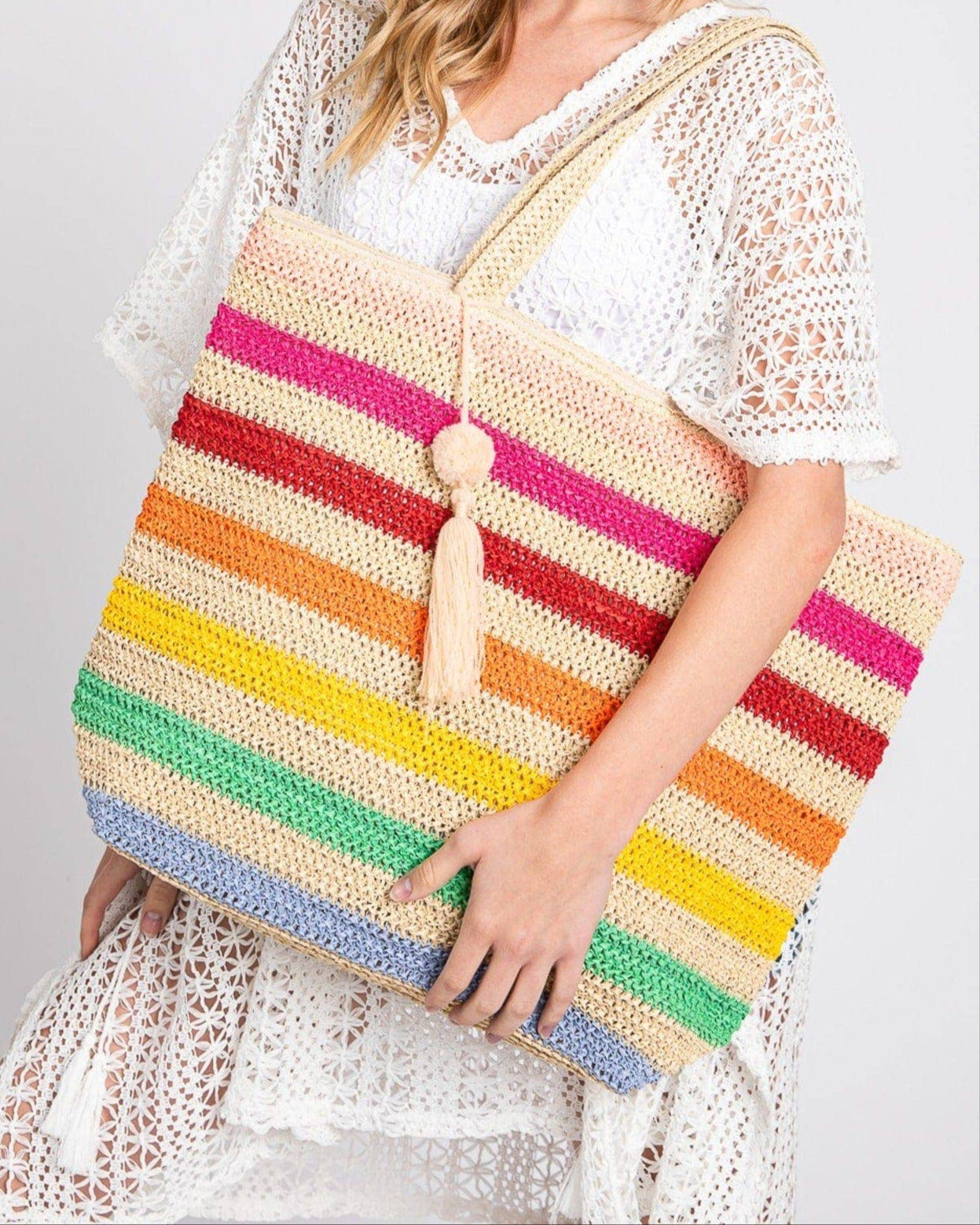 Rainbow stripe crochet beach tote bag with tassel and zipper closure.